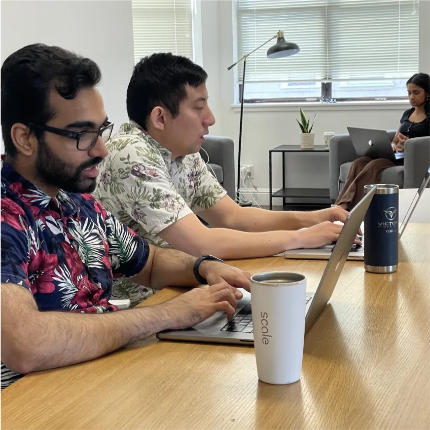 Two team members working on their laptops